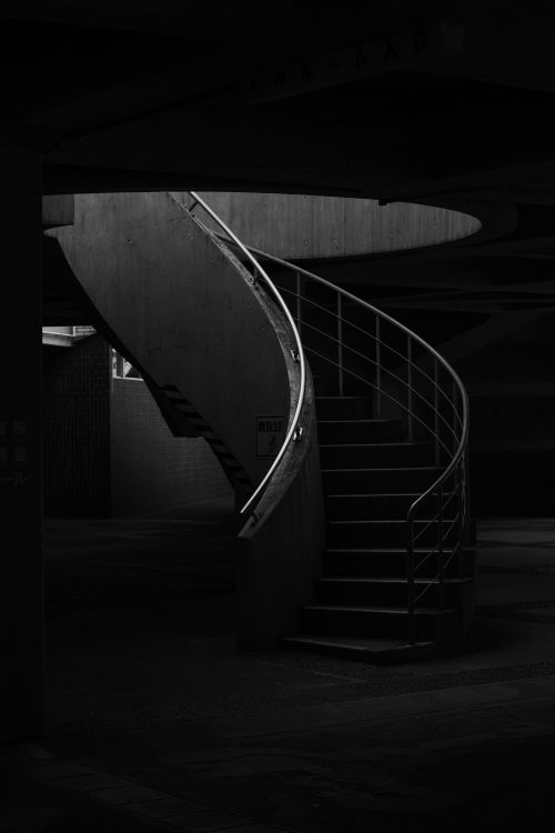 Free Captivating black and white image of a spiral staircase in an urban setting. Stock Photo
