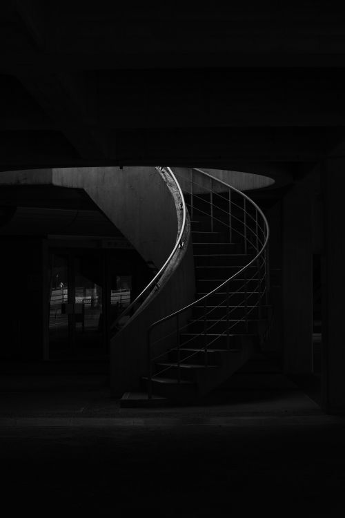 Free A dramatic monochrome spiral staircase in an urban setting, emphasizing curves and contrast. Stock Photo