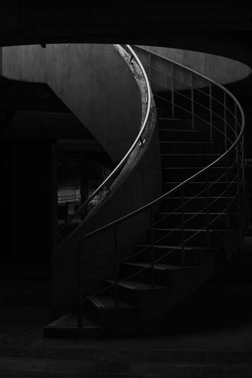 Free Black and white photo of a spiral staircase in an urban environment, evoking a moody atmosphere. Stock Photo