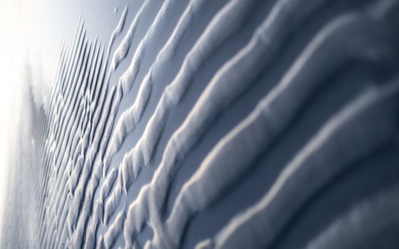 A detailed view of an abstract smooth textured surface with light and shadows enhancing depth.