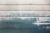 一幅油漆剥落的乡村木墙的详细图像，展示了适合设计项目的复古纹理