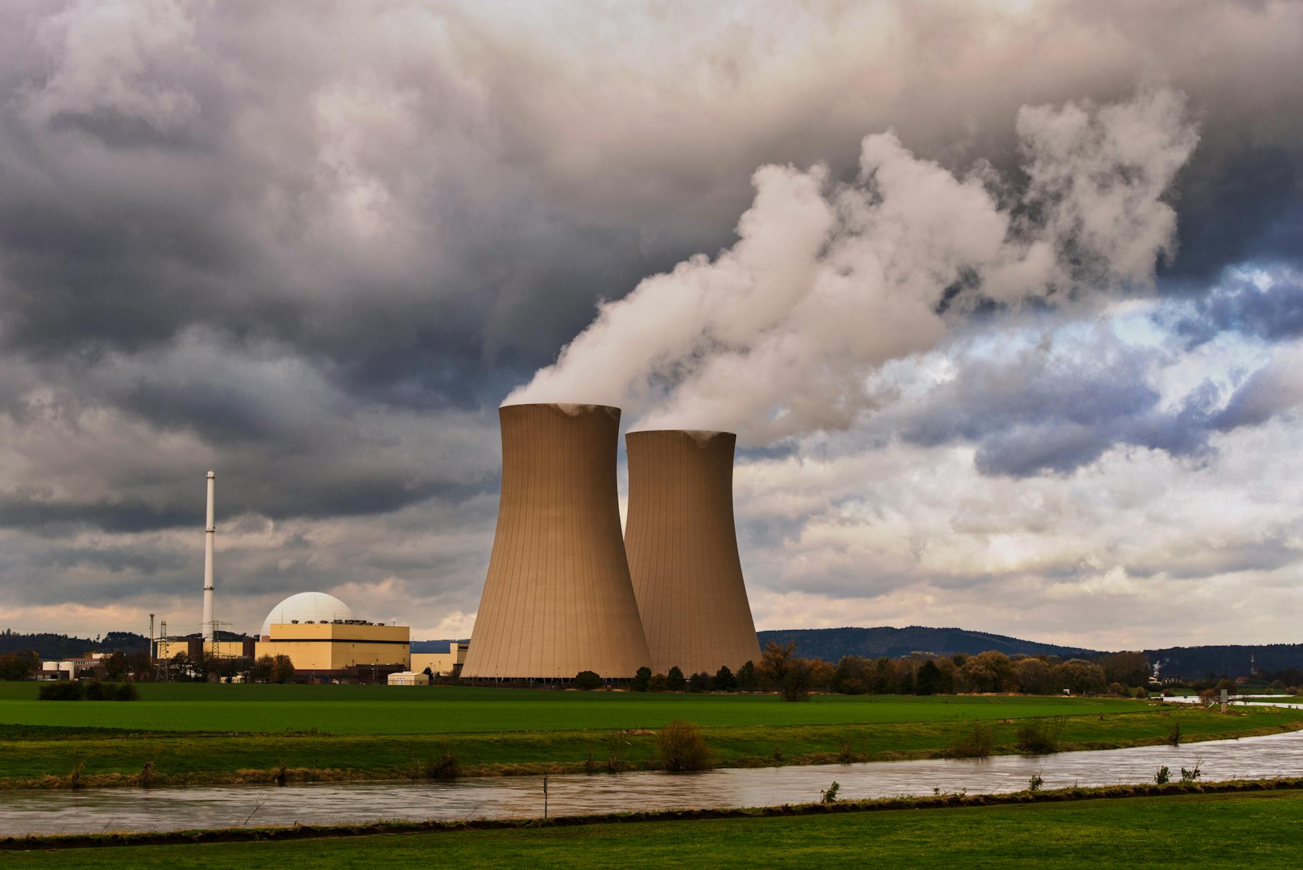Scenic view of a nuclear power plant with cooling towers emitting steam in Hameln, Germany.