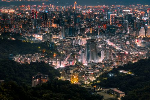 Free Vibrant night view of a modern cityscape with illuminated skyscrapers and dynamic urban lights. Stock Photo