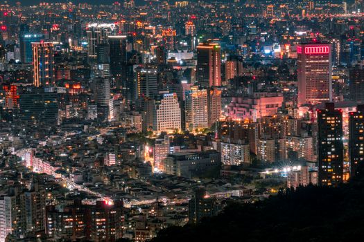 A breathtaking aerial view of an illuminated city skyline at night, showcasing vibrant lights and bustling urban life.