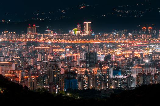 Stunning view of a bustling city skyline at night with vibrant lights and urban buildings.