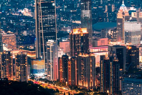 Free Stunning aerial night view of a vibrant cityscape illuminated with skyscrapers and bright lights. Stock Photo