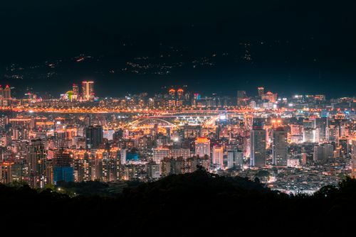 Free A stunning evening cityscape of Taipei with illuminated skyscrapers and vibrant city lights. Stock Photo
