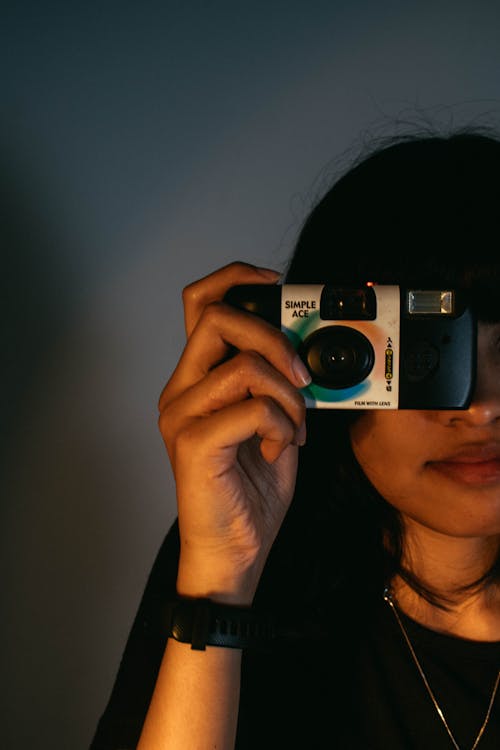 Young Woman Taking a Picture with a Disposable Camera 
