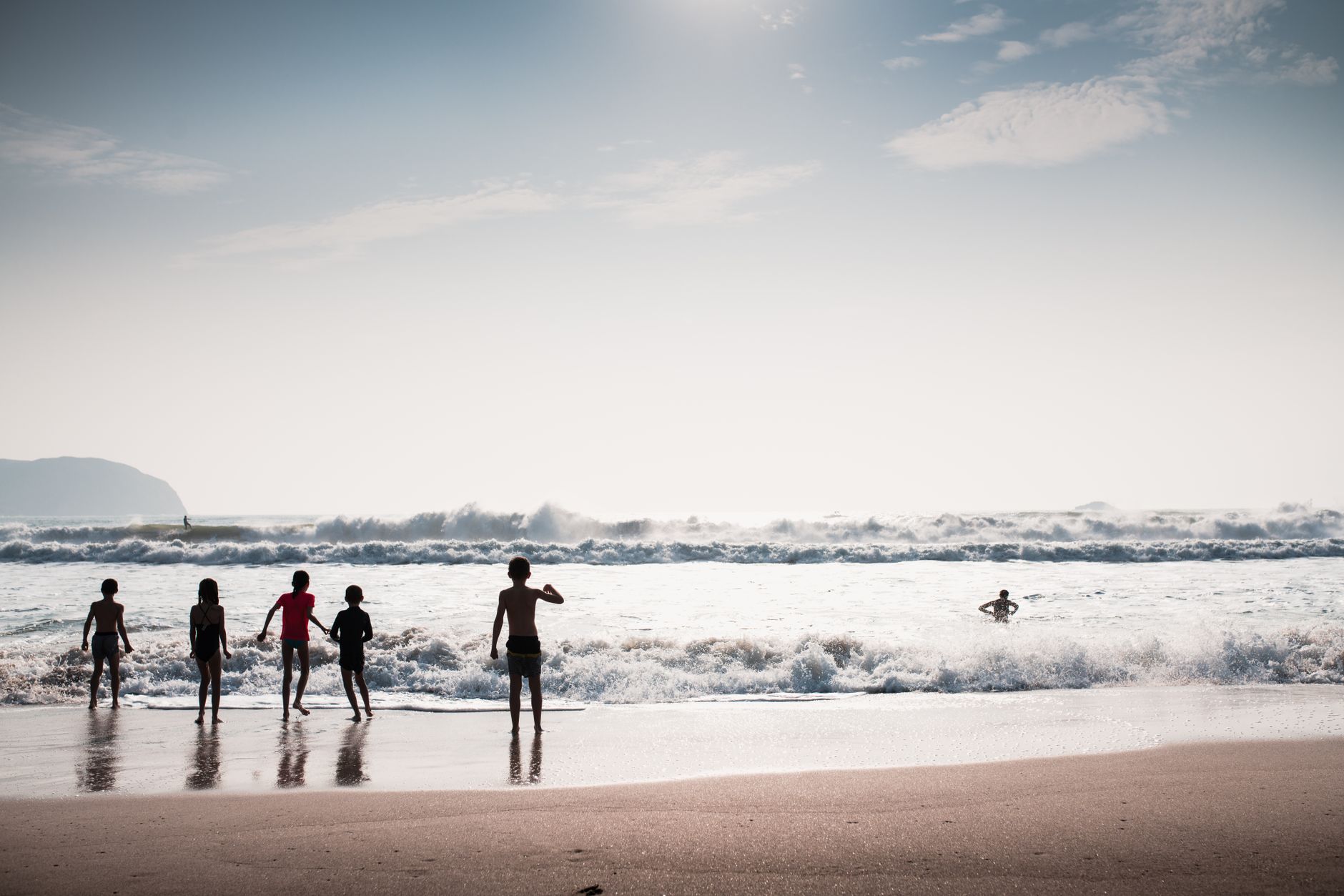 Group of friends playing by the sea surf on a sunny day at the beach. — Trójmiasto