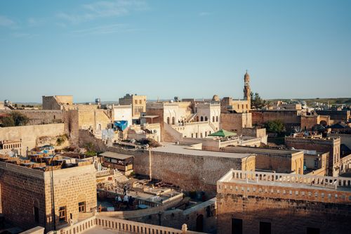 Free Explore the scenic view of Midyat's traditional architecture under a clear blue sky. Stock Photo