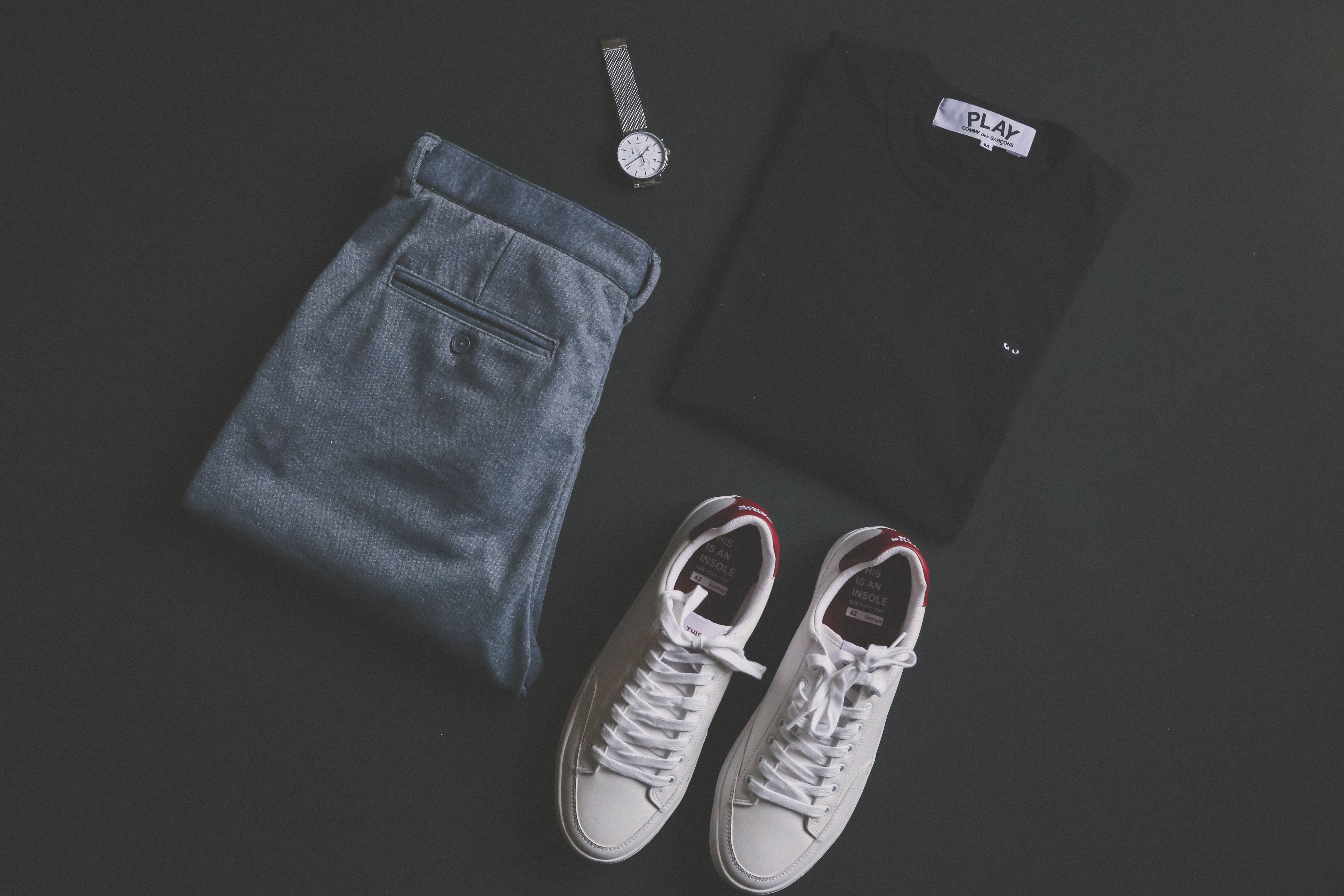 An outfit laid out for the next day: folded pants, a shirt, shoes, and a watch
