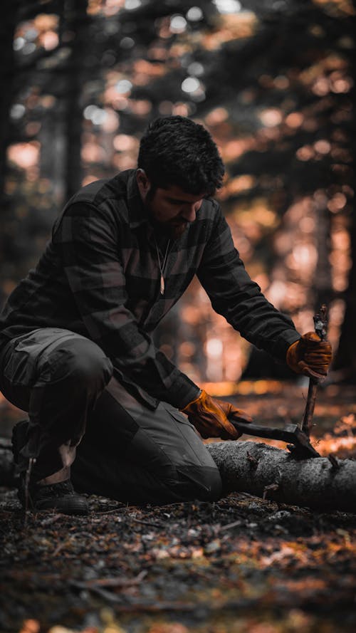 Man Using an Axe to Chop off a Branch 