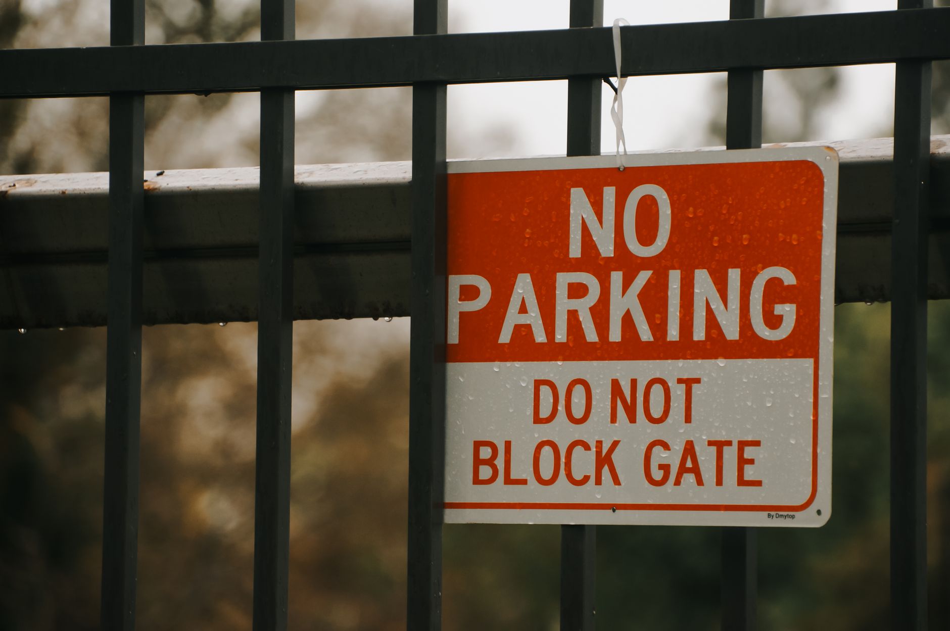 Close-up of a 'No Parking' sign on a metal gate in California City, emphasizing no blocking access.