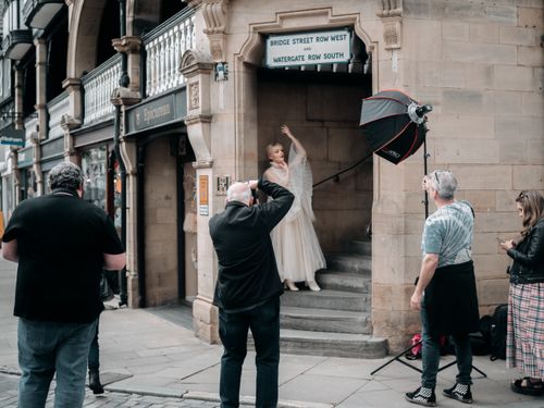 Free A photo shoot taking place outdoors with a focus on vintage fashion and a team of photographers. Stock Photo