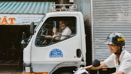 Smiling Man Driving a Truck with his Son 