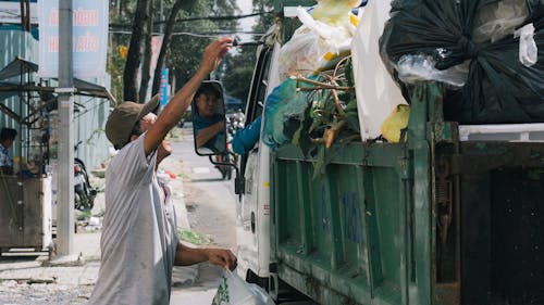 Man Putting Trash on the Truck 