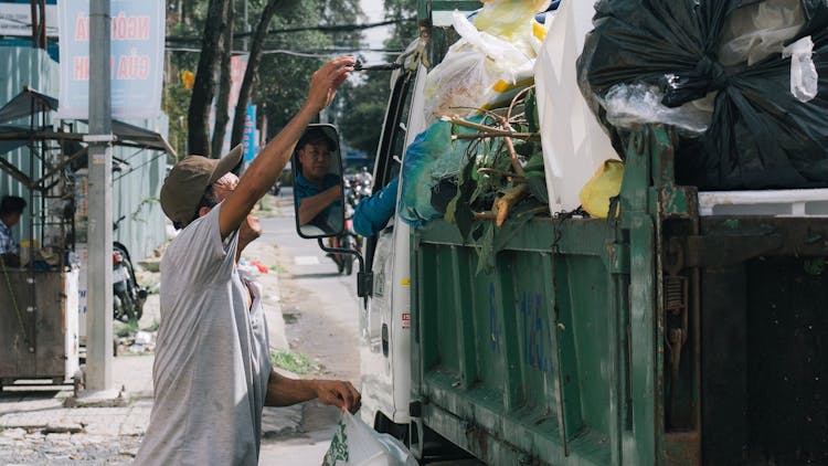 Man Putting Trash On The Truck 