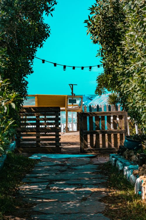 Free Charming beach entrance with wooden gate and trees in Dar Bou Azza, Morocco. Stock Photo