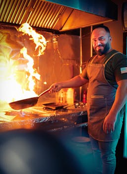 A chef skillfully cooks with high flames in Sulaymaniyah kitchen.
