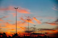 充满活力的日落与路灯剪影共同勾勒出宁静的天际线