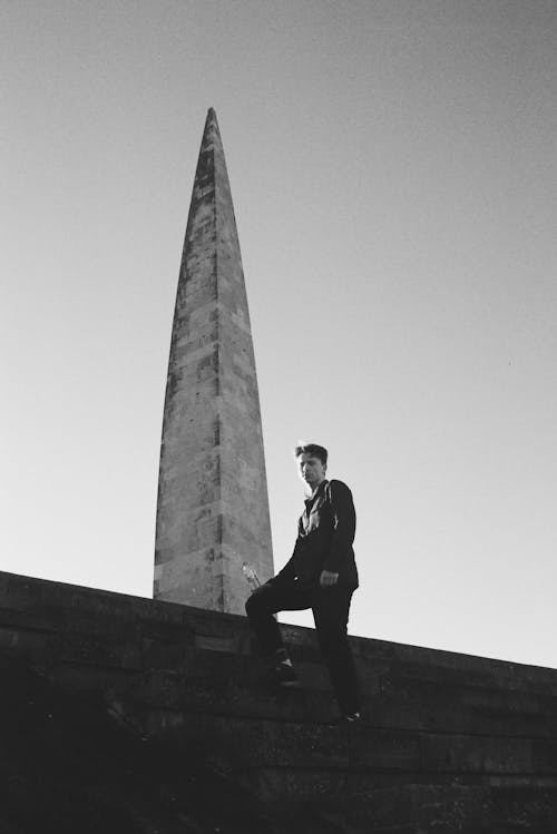 Free Grayscale Photo of Man Standing Beside Monument Stock Photo