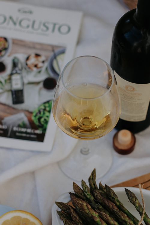 Free Glass of white wine with asparagus on a white tablecloth, creating a sophisticated ambiance. Stock Photo