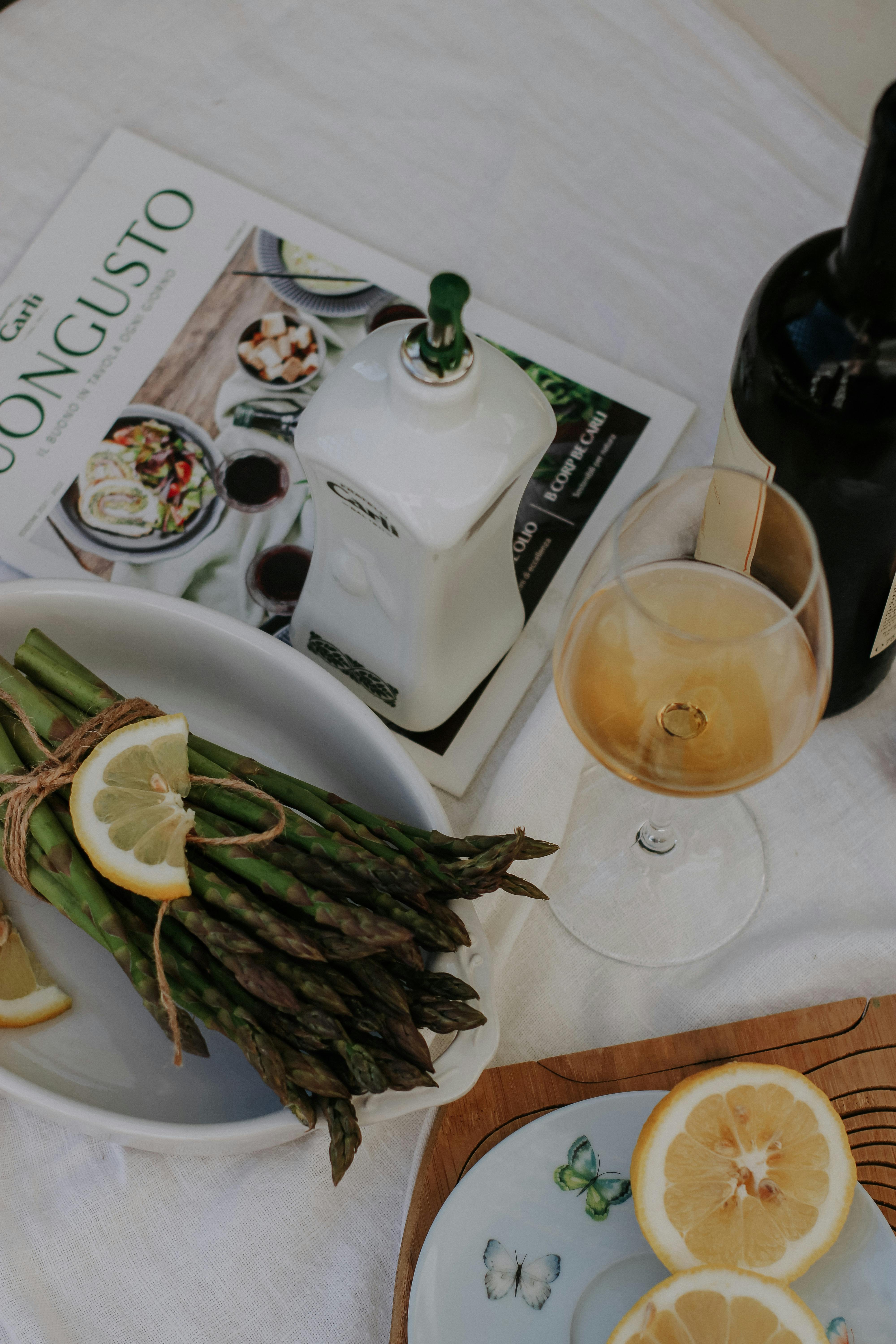 Chic table scene featuring asparagus, wine, and lemon slices for culinary inspiration.