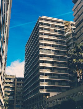 蔚蓝天空下的城市景观中，矗立着当代多层公寓楼