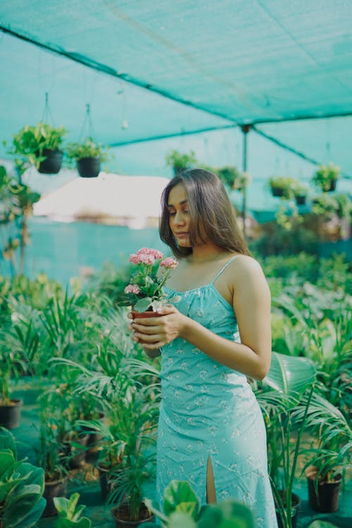 Brunette Woman in Green Dress and with Plants