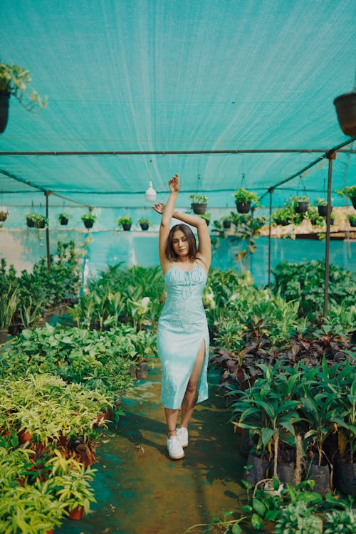 Woman in Green Dress Posing among Plants