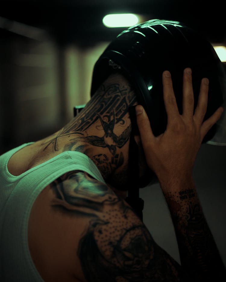 Tattooed Person Taking Off Motorcycle Helmet