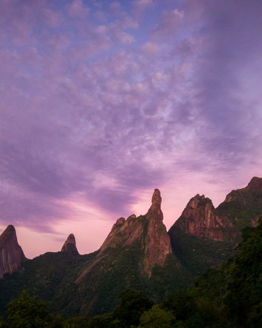 Breathtaking view of jagged peaks silhouetted by a vibrant purple sunset sky.