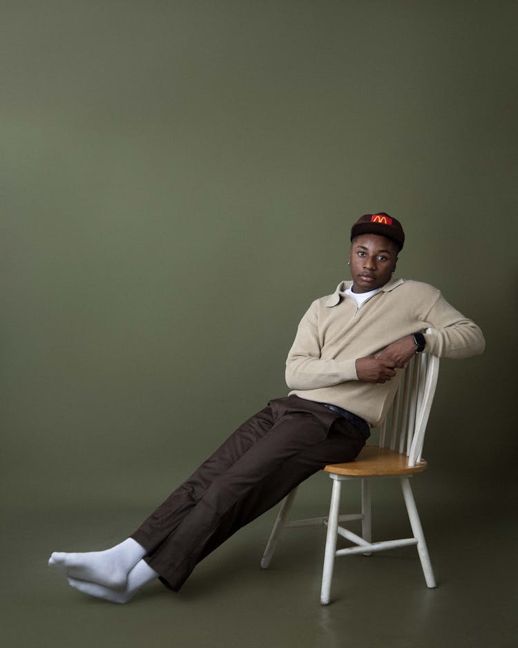 Stylish Man Sitting On Chair In Studio