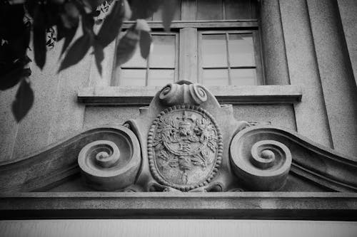 Black and White Photo of a Coats of Arms on a Building Facade
