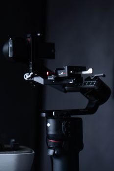Close-up of a modern camera gimbal against a dark backdrop, emphasizing sleek design.