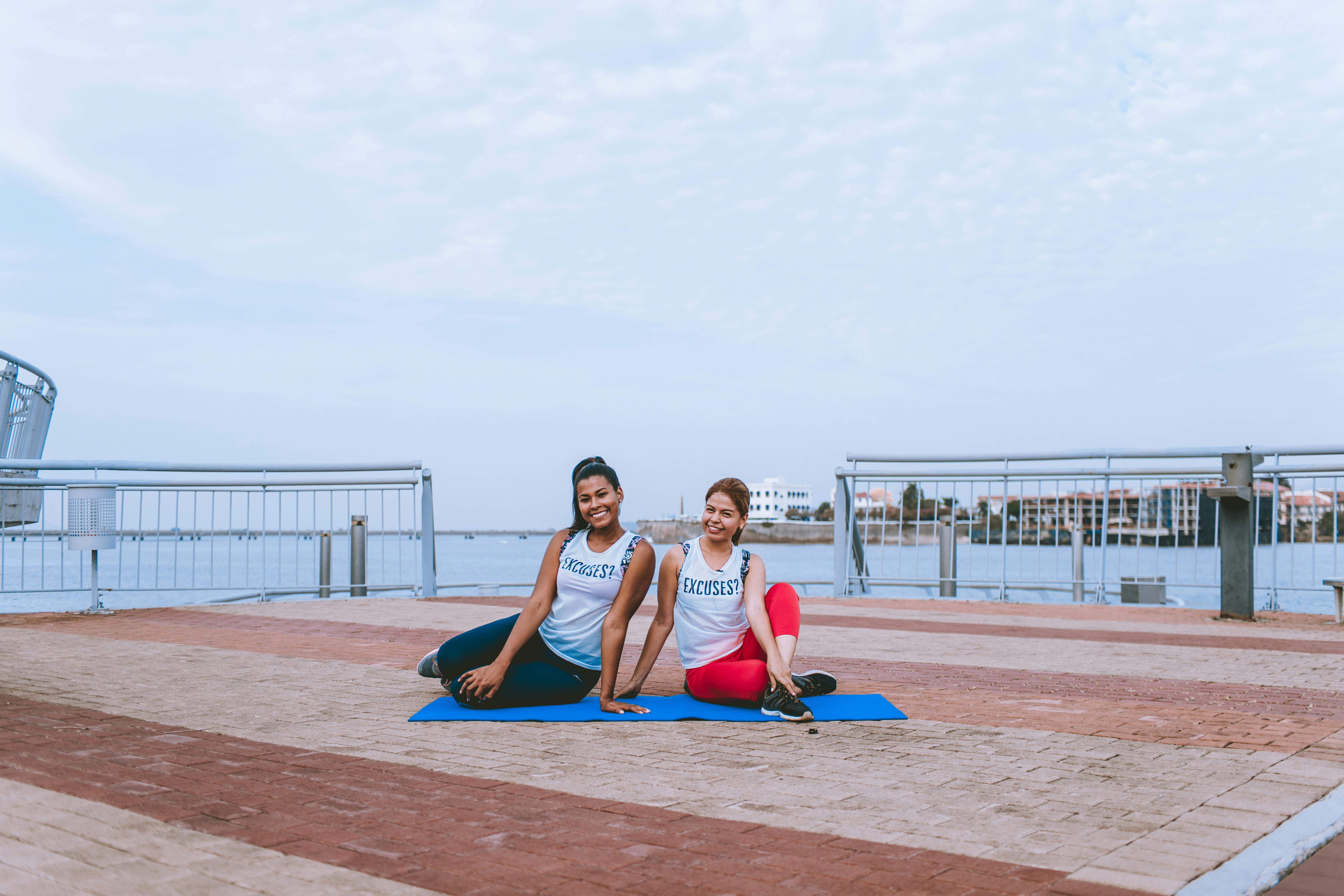 一个晴朗的日子里，两名女子在河边的甲板上上瑜伽课