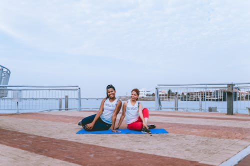 Two Women Sitting on Yoga Mat