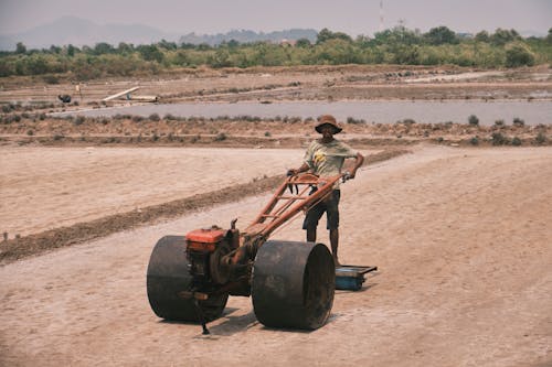 Photo of a Man Working in a Dry Field
