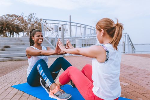 Free Two women exercising together outdoors, sharing a fun workout session with smiles and motivation. Stock Photo