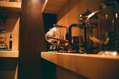 Selective Focus Photography of Coffee Pitchers on Shelf