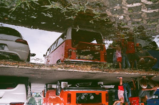 这幅作品以独特的视角，创意地展现了一辆老式货车与雨水坑中的人