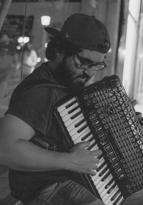 Man in Cap Playing Accordion in Black and White