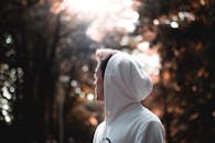 阳光下，一名穿着连帽衫的年轻人侧影，呈现出艺术散景效果