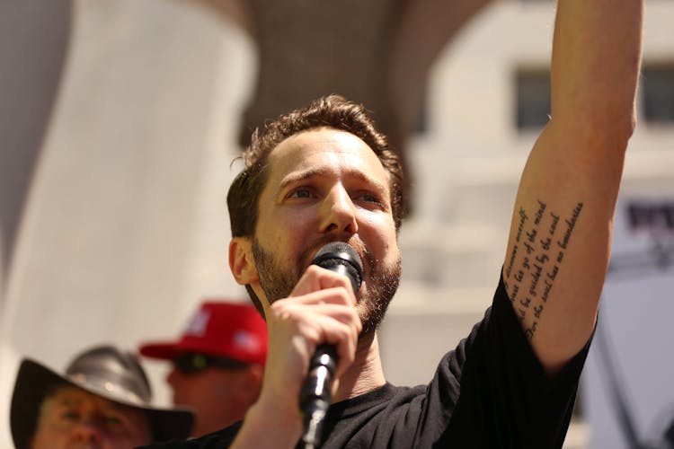 Photo Of A Man Speaking On Stage