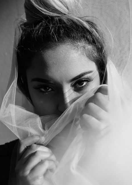 Artistic black and white portrait featuring a woman with expressive eyes and a veil creating a mysterious mood.