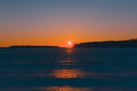 白雪覆盖的田野上，迷人的冬季日落让天空充满活力