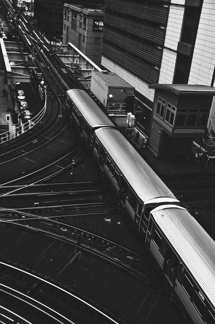 Black and white aerial view of a train at a railway station in downtown Chicago.