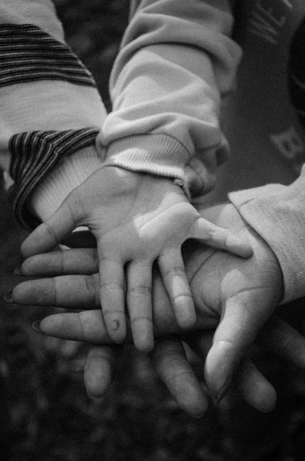Trois générations de mains réunies, symbolisant la famille