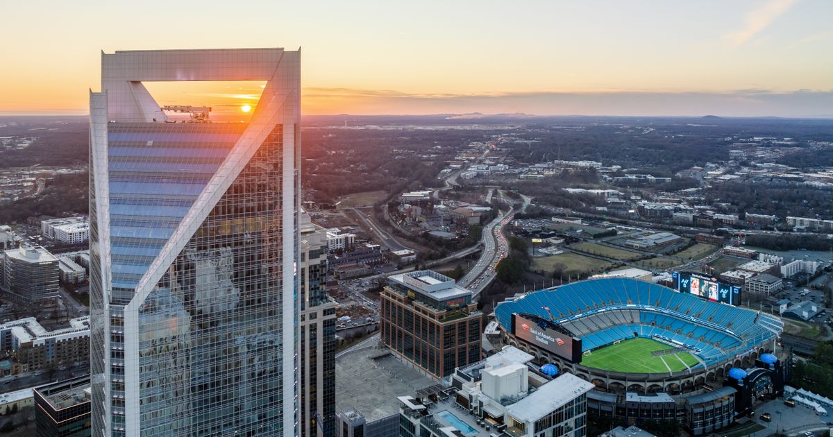 Aerial view of the Charlotte skyline near Bank of America Stadium at sunset.