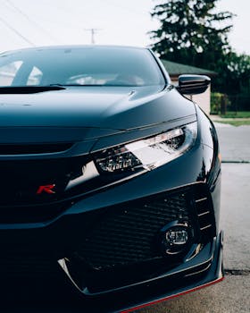 黑色跑车车头的动态特写，展现了时尚的设计和现代的前灯